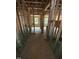 Unfinished hallway showing studs and windows, providing a glimpse of the home's layout at 444 Golden Dragonfly St, Wake Forest, NC 27587