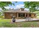 Brick home backyard featuring a brick patio with outdoor seating, screened porch, and manicured lawn at 46 Spring Haven Ln, Willow Springs, NC 27592