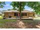 Brick home backyard featuring a brick patio with outdoor seating, screened porch, and lush landscaping at 46 Spring Haven Ln, Willow Springs, NC 27592