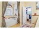 Bathroom featuring a jacuzzi tub, decorative curtains, and linen closet for added storage at 46 Spring Haven Ln, Willow Springs, NC 27592