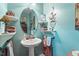 Charming powder room with pedestal sink, decorative mirror, and coastal-inspired decor at 46 Spring Haven Ln, Willow Springs, NC 27592