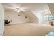 Bright bonus room featuring neutral carpet, ceiling fans, and dormer windows for natural light and a cozy feel at 46 Spring Haven Ln, Willow Springs, NC 27592