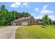 Spacious brick home featuring a three-car garage, lush landscaping, and a well-maintained lawn at 46 Spring Haven Ln, Willow Springs, NC 27592