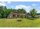 Charming brick home with well-manicured lawn, lush trees, and attached garages, offering curb appeal and functionality at 46 Spring Haven Ln, Willow Springs, NC 27592