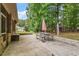 Outdoor patio area with stone hardscaping, an umbrella-covered picnic table, and lush greenery views, perfect for relaxation at 46 Spring Haven Ln, Willow Springs, NC 27592