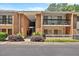 Exterior of a brick condo building with balconies and well-maintained landscaping at 4709 Edwards Mill Rd # H, Raleigh, NC 27612