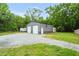 Detached garage with dual bay doors, gravel driveway, and a grassy lawn at 5129 Neighbors Rd, Mebane, NC 27302