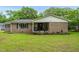 Brick home with inviting front porch, rocking chairs, and landscaping, set on a large lot with mature trees at 5129 Neighbors Rd, Mebane, NC 27302
