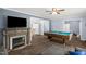 Open-concept living room with hardwood floors, fireplace, pool table, and seamless flow to the dining area and kitchen at 5129 Neighbors Rd, Mebane, NC 27302
