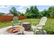 Inviting backyard with green lawn, mature trees, and comfortable seating area with a fire pit at 5312 Suntan Lake Dr, Raleigh, NC 27610