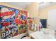 Bright bathroom with a comic-themed shower curtain, vanity with sink, and functional storage shelves at 5312 Suntan Lake Dr, Raleigh, NC 27610
