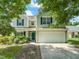 Two-story home with a two-car garage, blue shutters, and landscaped front yard at 5312 Suntan Lake Dr, Raleigh, NC 27610