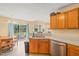 Kitchen featuring wood cabinets, updated appliances, and a sink with a view of the backyard and dining area at 5312 Suntan Lake Dr, Raleigh, NC 27610