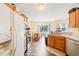 Galley-style kitchen with wood cabinets, modern appliances, and a view into the dining area and backyard at 5312 Suntan Lake Dr, Raleigh, NC 27610