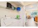 Efficient laundry area with modern washer and dryer, complemented by convenient storage shelving at 5312 Suntan Lake Dr, Raleigh, NC 27610