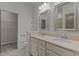 Well-lit bathroom with double sinks, walk-in closet, and neutral-toned tile flooring at 5320 Jessip St, Morrisville, NC 27560