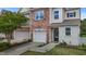Well-kept townhome showcasing a stone facade, attached garage, and nicely landscaped front yard at 5320 Jessip St, Morrisville, NC 27560