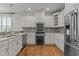 Well-lit kitchen features stainless steel appliances, wood floors, white cabinetry, and decorative backsplash at 5320 Jessip St, Morrisville, NC 27560