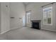 Comfortable living room features neutral carpet, plantation shutters, a fireplace, and an exterior access door at 5320 Jessip St, Morrisville, NC 27560