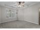 Large main bedroom featuring a tray ceiling, ceiling fan, neutral carpet, and plantation shuttered windows at 5320 Jessip St, Morrisville, NC 27560