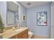 Powder room featuring granite countertops, wooden vanity, and light blue walls at 601 W Rosemary St # 416, Chapel Hill, NC 27516
