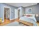 Cozy bedroom with hardwood floors, white bedding, walk-in closet, and a modern decorative bench at 601 W Rosemary St # 416, Chapel Hill, NC 27516