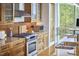 Modern kitchen with stainless steel gas range, wood cabinets, and tiled backsplash at 601 W Rosemary St # 416, Chapel Hill, NC 27516