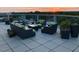 Community roof deck with comfortable seating, potted plants, and sunset views at 601 W Rosemary St # 416, Chapel Hill, NC 27516