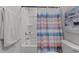 Clean bathroom with a shower-tub combo, striped shower curtain, and a decorative accent at 6415 Mentor Pl, Raleigh, NC 27616