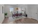 Bright dining room featuring a modern table with red cushioned chairs, stylish lighting, and wood flooring at 6415 Mentor Pl, Raleigh, NC 27616