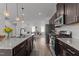Contemporary kitchen with stainless appliances, granite countertops, and dark wood cabinetry at 6415 Mentor Pl, Raleigh, NC 27616