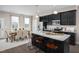 Modern kitchen features an island with countertop seating, granite countertops, stainless steel appliances, and dining area at 700 Tambor Rd, Durham, NC 27713
