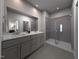 Bright bathroom showcasing a double sink vanity, a large mirror, and a modern glass-enclosed shower at 717 Chandler Stone Dr, Zebulon, NC 27597