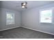 This bedroom features neutral paint and carpeting, a ceiling fan, and natural light from the two windows at 722 Orchard Dr, Graham, NC 27253