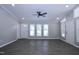 Living room featuring three windows, with a door, a ceiling fan and lots of open space at 722 Orchard Dr, Graham, NC 27253