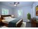 Comfortable primary bedroom with a ceiling fan, two windows and a roomy closet at 722 Orchard Dr, Graham, NC 27253
