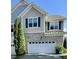Beautiful two-story townhome showcasing a two-car garage, brick accents, and tidy landscaping at 7241 Terregles Dr, Raleigh, NC 27617