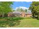 Brick home with covered patio, an outdoor fireplace, and a spacious backyard, perfect for outdoor gatherings at 801 Pinehurst Dr, Chapel Hill, NC 27517