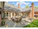 Outdoor patio with comfortable seating, a dining table, and a well-manicured lawn at 801 Pinehurst Dr, Chapel Hill, NC 27517