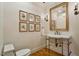 Charming powder room featuring elegant framed botanical prints, ornate mirror and vanity with custom lighting at 801 Pinehurst Dr, Chapel Hill, NC 27517