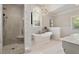 This luxury bathroom features marble tile, a modern stand-alone tub and a glass-enclosed walk-in shower at 801 Pinehurst Dr, Chapel Hill, NC 27517