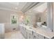 This bathroom is equipped with double sinks, a large mirror, modern tiling, and a stand-alone bathtub at 801 Pinehurst Dr, Chapel Hill, NC 27517