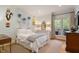 Bright bedroom with a full-sized bed, hardwood floors, large windows, and access to a balcony at 801 Pinehurst Dr, Chapel Hill, NC 27517