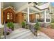 Inviting front porch boasts a brick facade, elegant iron railings, and a beautiful arched wood front door at 801 Pinehurst Dr, Chapel Hill, NC 27517