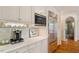 This kitchen has a stainless fridge, microwave, coffeemaker, white cabinets and countertops with hardwood floors at 801 Pinehurst Dr, Chapel Hill, NC 27517
