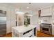 Bright kitchen boasts stainless steel appliances, a center island, and white cabinetry for a clean, modern look at 801 Pinehurst Dr, Chapel Hill, NC 27517