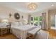Spacious main bedroom boasts beautiful hardwood floors, chandelier, and large windows overlooking the serene backyard at 801 Pinehurst Dr, Chapel Hill, NC 27517