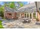 Spacious stone patio features comfortable seating, a dining area, and outdoor TV perfect for entertaining at 801 Pinehurst Dr, Chapel Hill, NC 27517