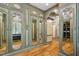 Spacious walk-in closet with custom cabinetry, mirror accents, hardwood floor, and recessed lighting at 801 Pinehurst Dr, Chapel Hill, NC 27517