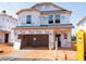New construction home with Tyvek wrap shows two-story framing and open garage at 804 Ottawa Dr, Garner, NC 27529